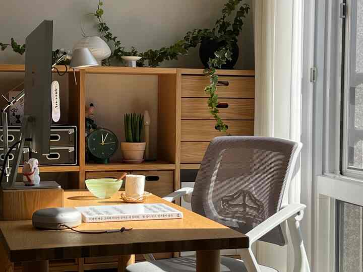 木目調と自然光が調和したホームオフィス、デスクと椅子、収納棚が配置されたシンプルなインテリア