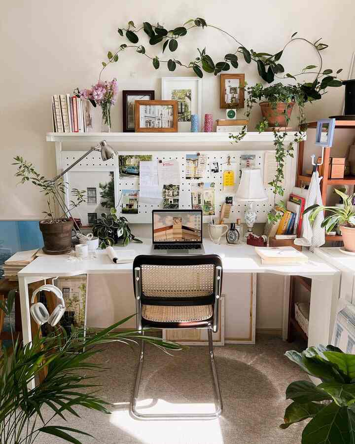 白と木目調のホームオフィス、机と椅子、多彩な植物が配置された雰囲気のあるインテリア