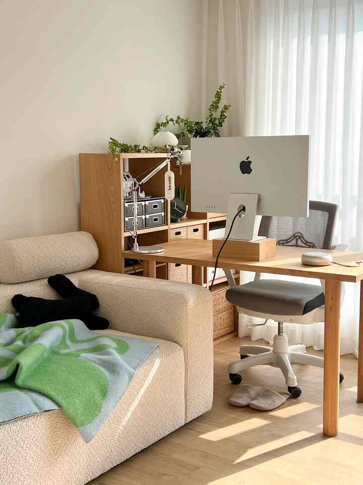 アイボリーとブラウンのナチュラルなホームオフィス、ソファとデスク、無印良品の収納棚が配置された温かみのある清潔感のあるインテリア