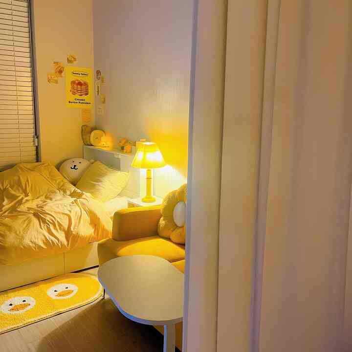 黄色のトーンが特徴的な狭い寝室、黄色い寝具とソファ、暖かい照明が配置された雰囲気のあるインテリア