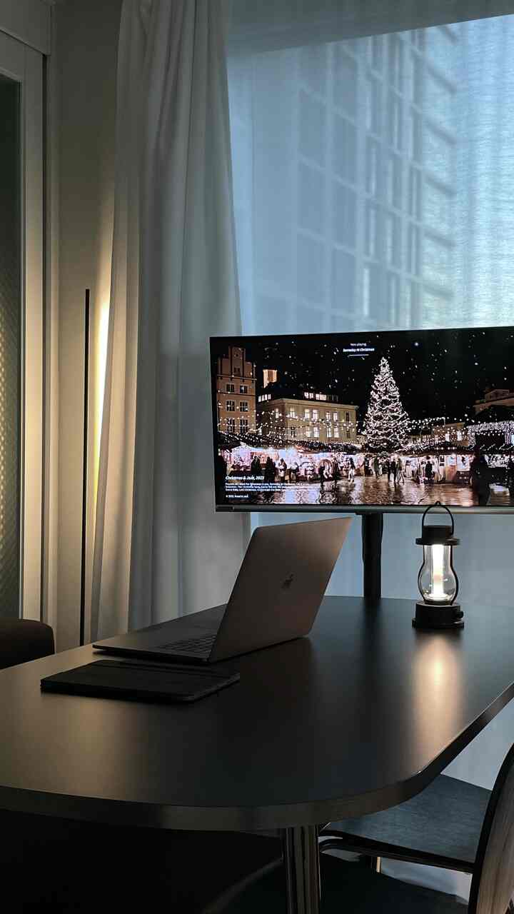 白と黒のトーンのホームオフィス空間、シンプルなダイニングテーブルとフロアランプが配置されたモダンな雰囲気のインテリア