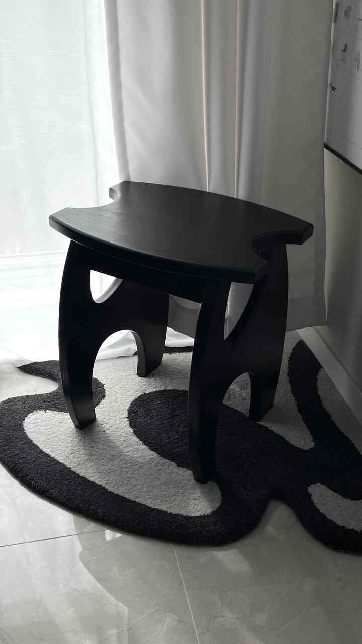 黒と白のトーンのキッチンコーナー、窓辺にスツールとコーナーカーペットが配置された雰囲気のある空間