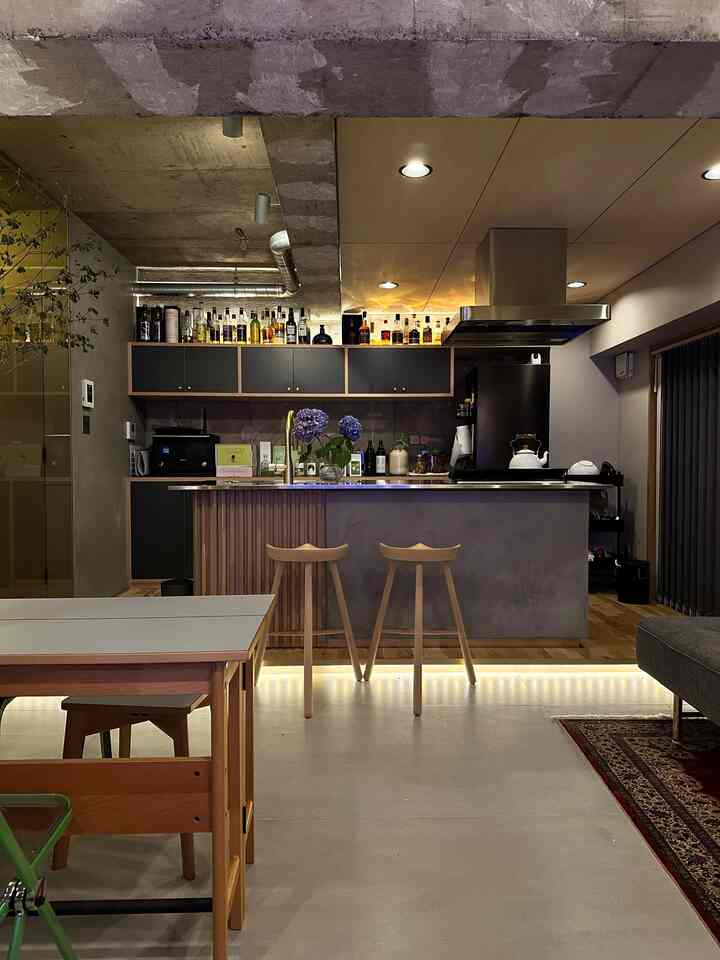 グレーとブラウンのトーンが特徴的なオープンキッチン付きのモダンなリビングスペース