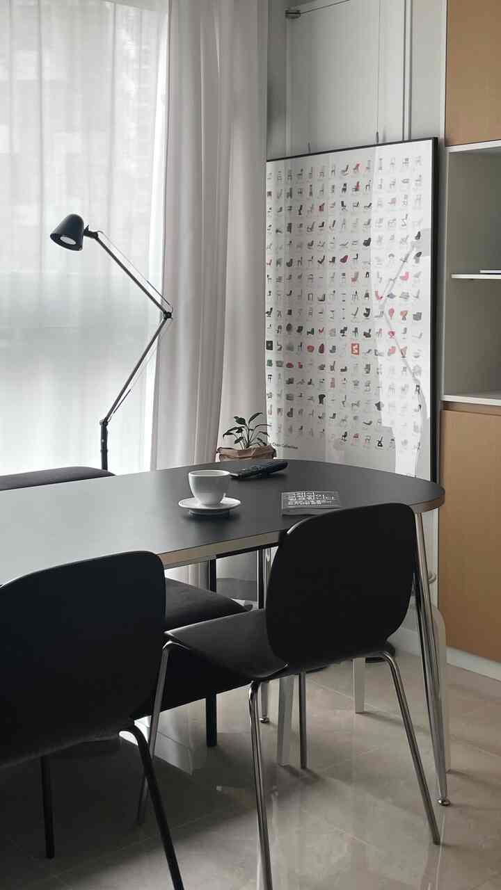 白いカーテンと黒いダイニングテーブル、椅子が配置されたシンプルでモダンなダイニングルーム