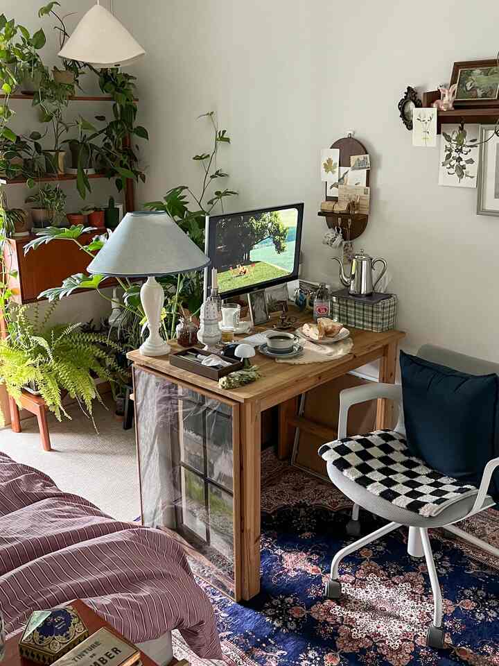 ナチュラルな雰囲気のホームオフィス、木製の机と豊富な植物が配置された居心地の良い作業空間