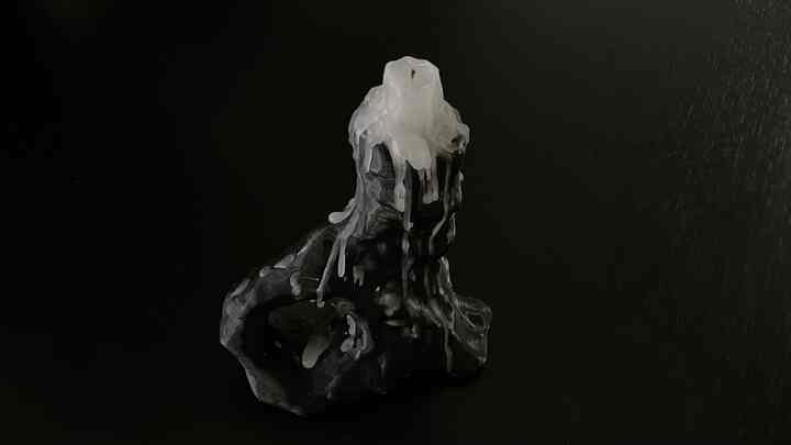 黒い背景に置かれた古木のキャンドルホルダーと溶けた白いキャンドルが印象的なキッチンダイニングテーブルのオブジェ