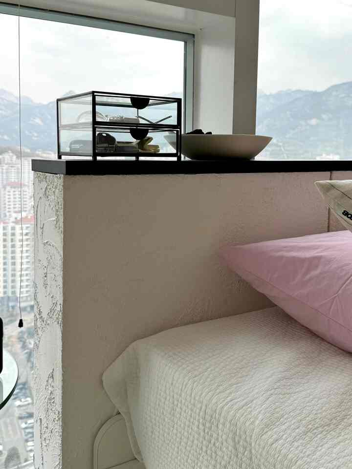 ホワイトとパステルカラーが調和した寝室空間、隙間収納とオーダー棚が配置された清潔感のあるDIY家具インテリア