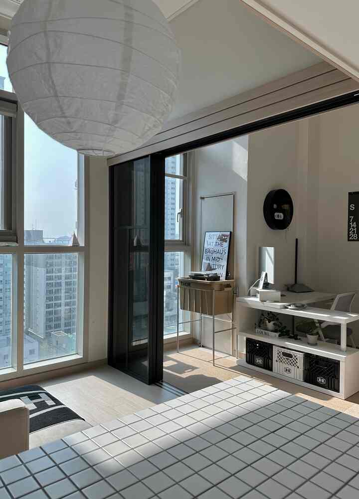 明るいホワイトトーンの書斎、窓辺に配置されたコンピューターデスクと収納ボックスが洗練されたインテリアを演出