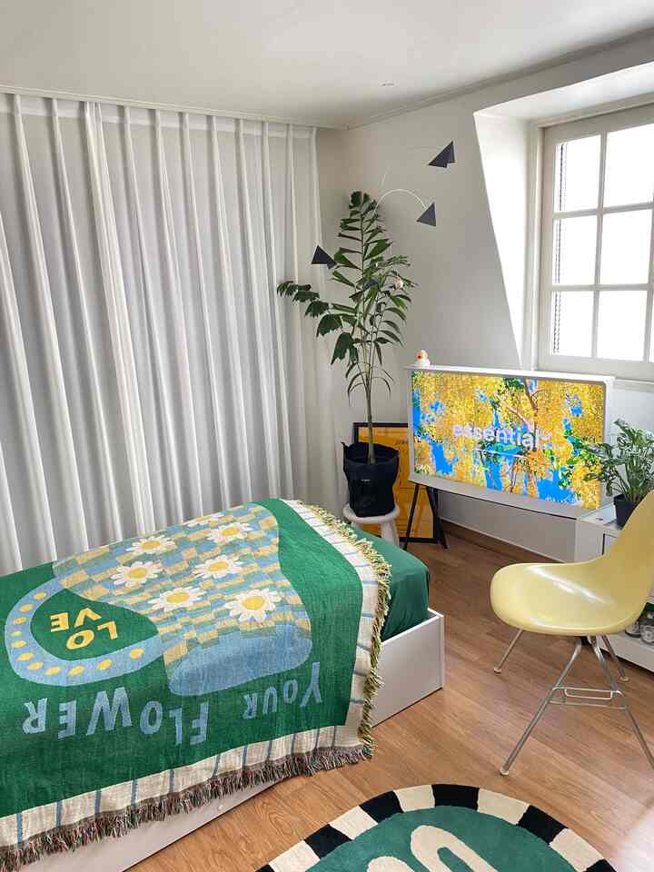 白と木目調が調和する6畳のワンルーム寝室、グリーンとイエローをアクセントにしたシンプルモダンな雰囲気のあるインテリア