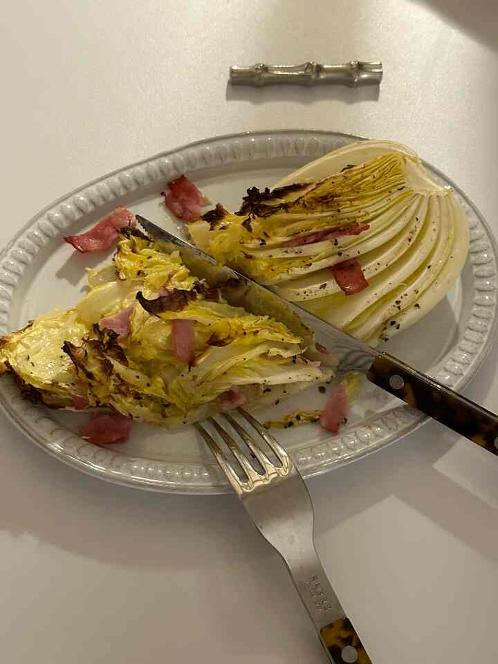 白いテーブルの上にオーブン用食器とカトラリーが置かれた調理済みの野菜料理