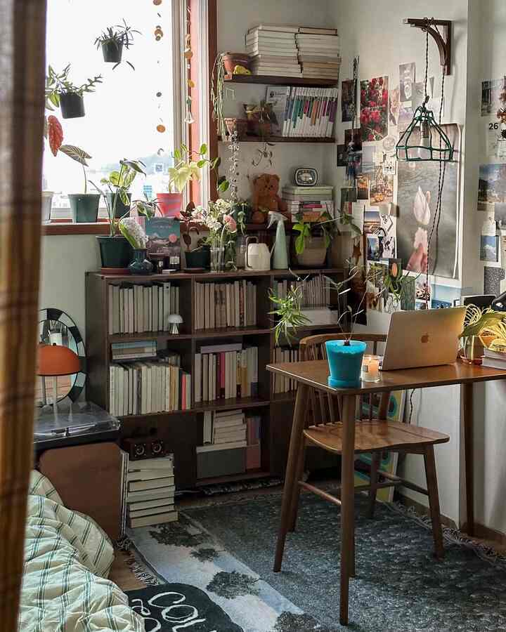 暖かい木目調のホームオフィス、書棚とデスクに多彩な植物が置かれた雰囲気のある読書空間