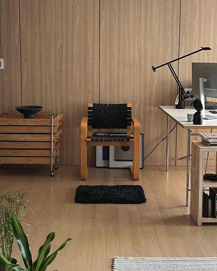 木目調の壁と床に囲まれたナチュラルなホームオフィス空間、中央にマグナス・オレセンのヴィンテージアームチェアが配置されている