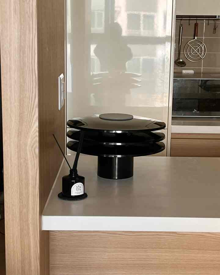 明るいナチュラルカラーのキッチンアイランドに黒いオブジェが置かれたシンプルでモダンなキッチンインテリア