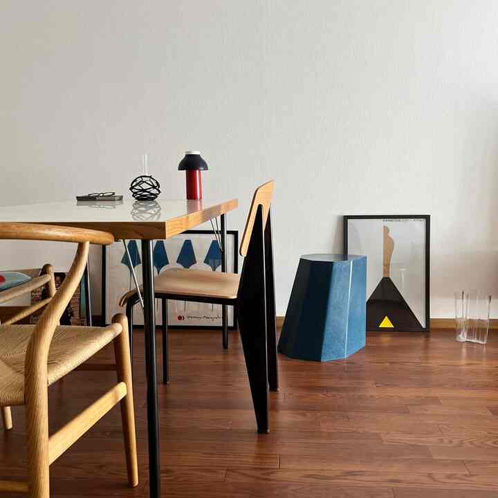 ナチュラルな木目調と白い壁が調和するシンプルなダイニング、モダンなオブジェが配置された雰囲気のあるインテリア