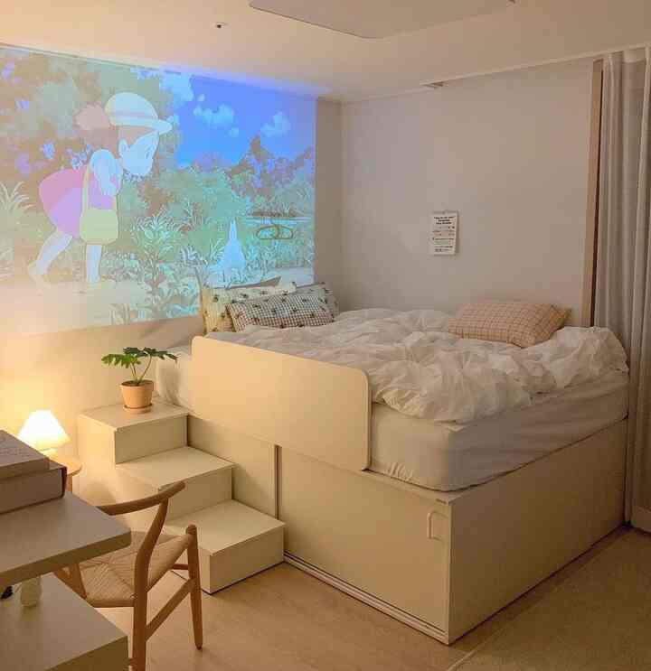 白と木目調の色合いが調和したコンパクトな寝室で、収納付きベッドとデスクが配置された雰囲気のあるインテリア