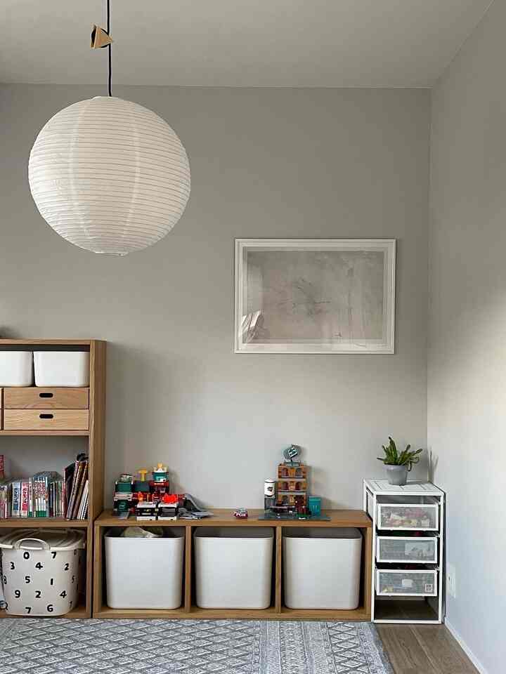 淡いグレーとホワイトのトーンの子供部屋、整頓された収納家具とおもちゃが配置されたジャパンディスタイルの印象的な空間