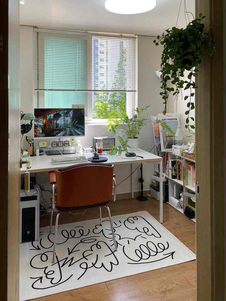 明るいホワイトとブラウンのトーンの小さな書斎兼ホームオフィス、植物と本棚が配置された雰囲気のあるワークスペース