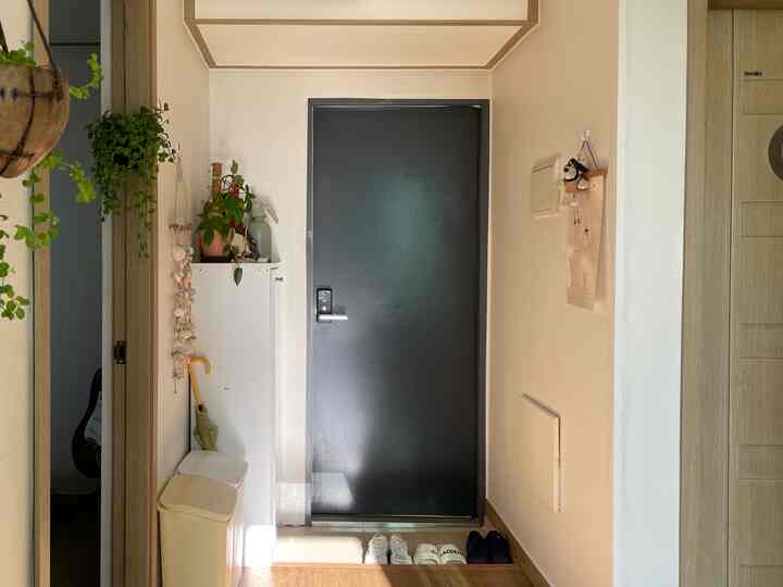 ホワイトとダークグレーの色調の玄関、シューズラックとリサイクルゴミ箱が整然と配置された狭い空間