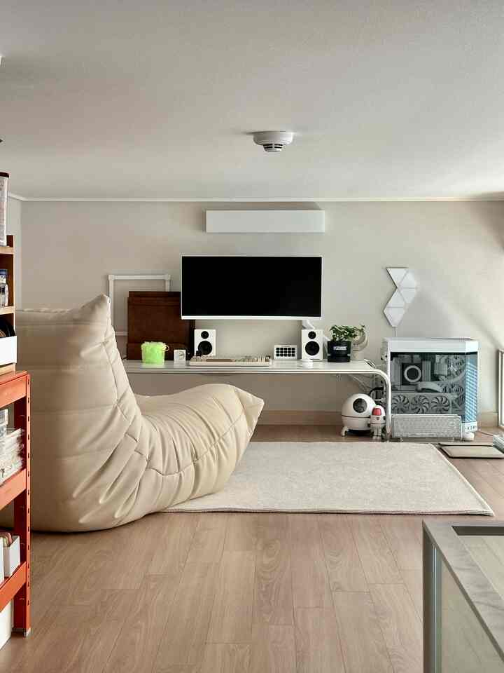 ベージュと木目調のホームオフィス、ゲーミングデスクと座敷ソファ、ラグが配置された落ち着いた雰囲気の空間