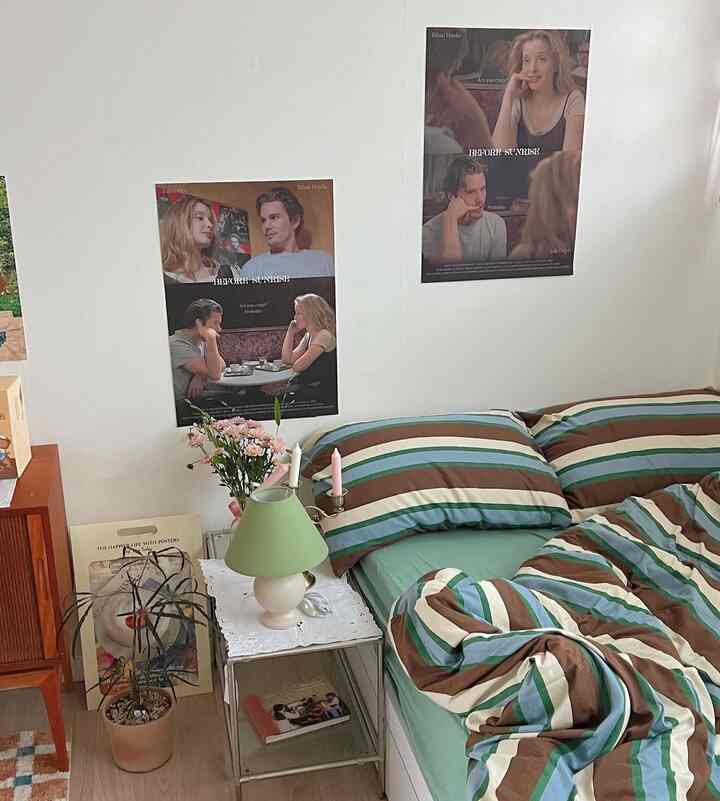 ナチュラルカラーとグリーン、ブラウンの調和が取れた寝室、ストライプの寝具とポスターが印象的な温かみのあるインテリア