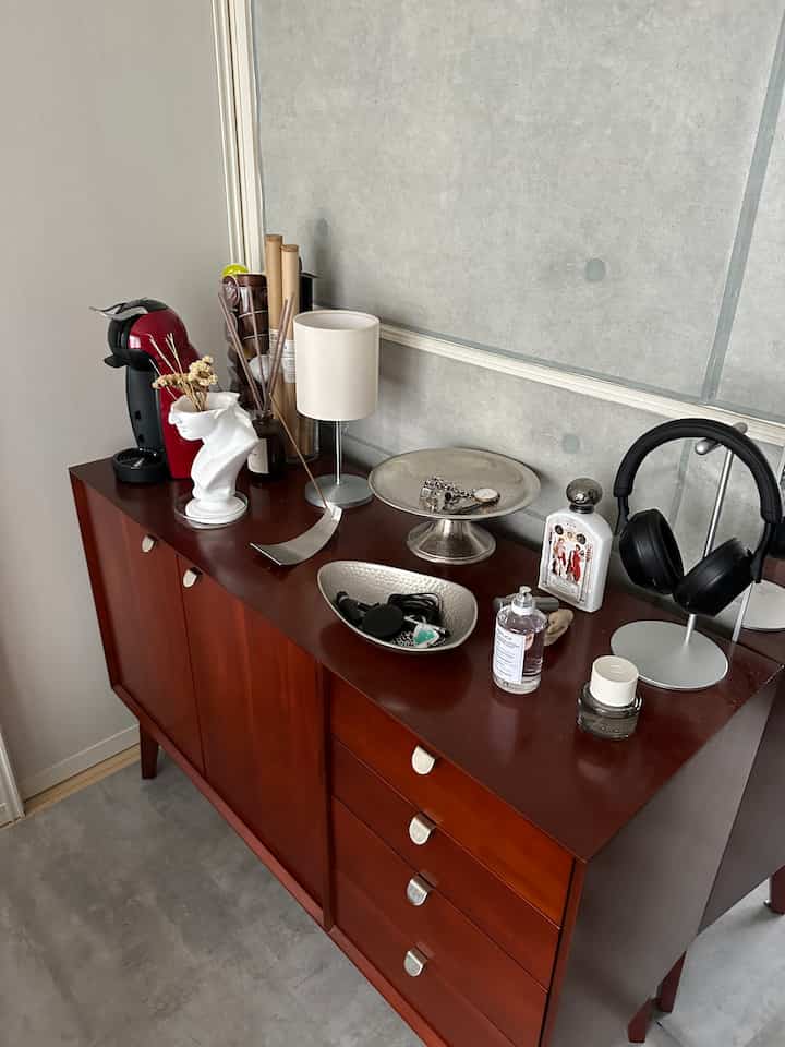 ウッド調のキャビネットとコンクリート壁が調和する1Kのコンパクトな室内、洗練されたインテリア