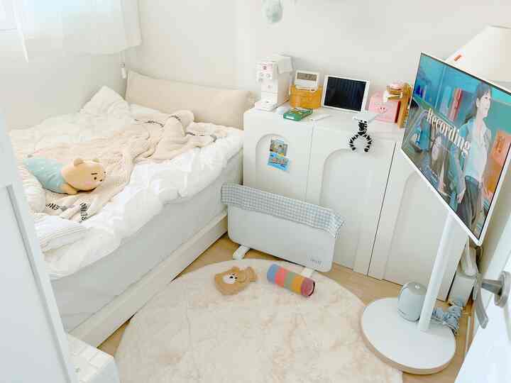 ホワイトとベージュのトーンの寝室、清潔感のあるベッドとコンパクトな家具が配置されたモダンで居心地の良い空間