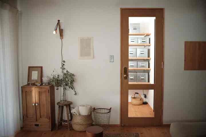 ナチュラルな木目調と透明なガラス扉が調和した狭い玄関とリビングの空間、シンプルで自然な雰囲気のインテリア