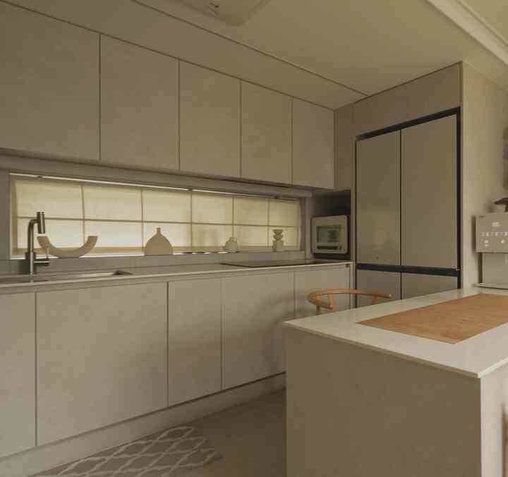 ベージュ色調のキッチン、リネン素材のローマンシェードとモダンな家具が調和した落ち着いた雰囲気のインテリア