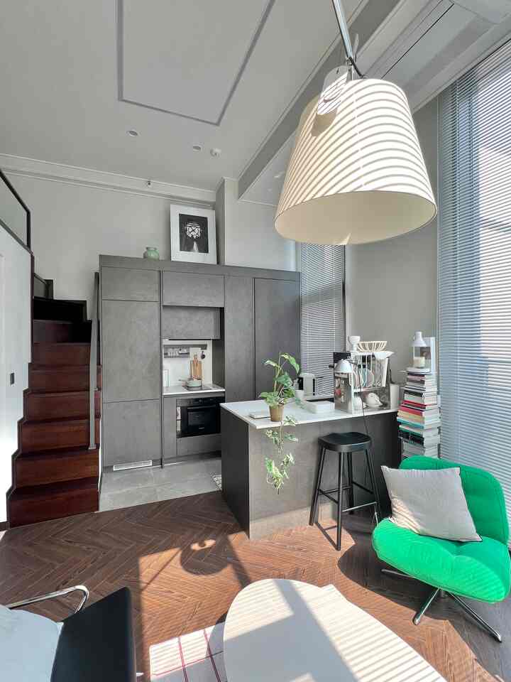 明るいグレーと木目調が調和した、階段のあるナチュラルでモダンなキッチンスペース