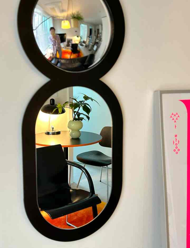 黒いフレームのユニークな平面と凸面鏡があるダイニング、モダンな雰囲気のあるインテリア