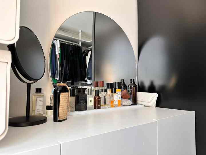 ホワイトトーンの狭い部屋に、化粧台と収納キャビネットが組み合わさった印象的な空間