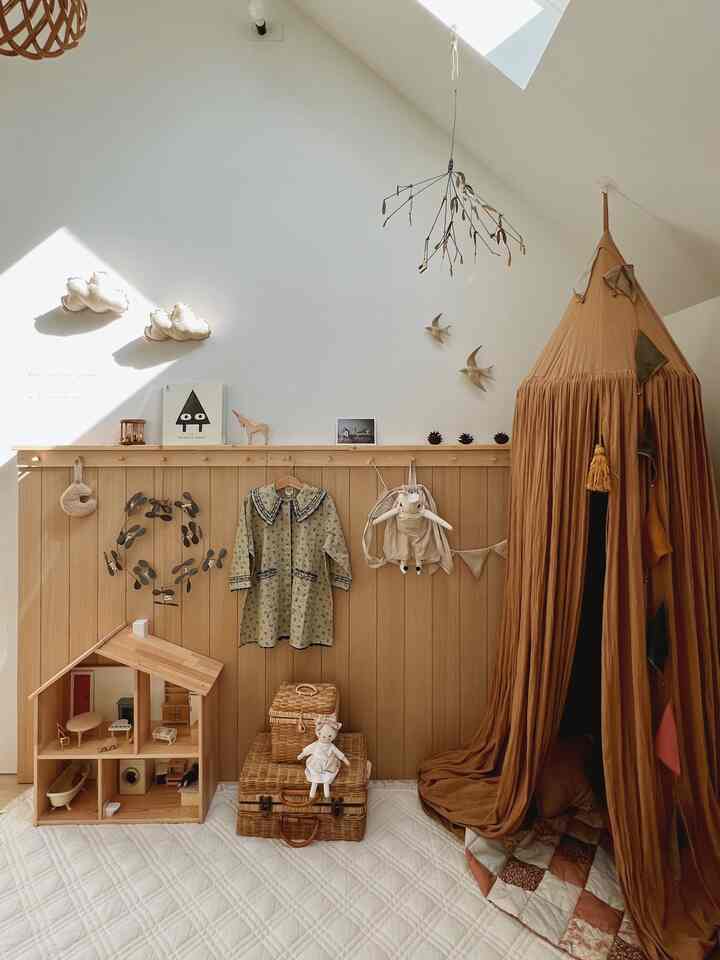 ベージュとホワイトの色調の遊び場、木製のおもちゃと壁棚が調和したナチュラルな雰囲気のインテリア