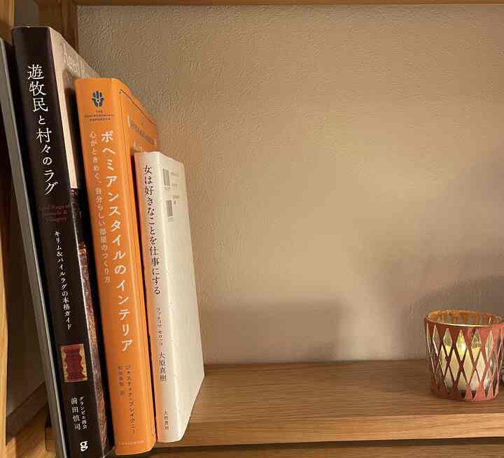 オレンジ色の本と木目調の本棚が配置された、落ち着いた雰囲気のあるインテリアスペース