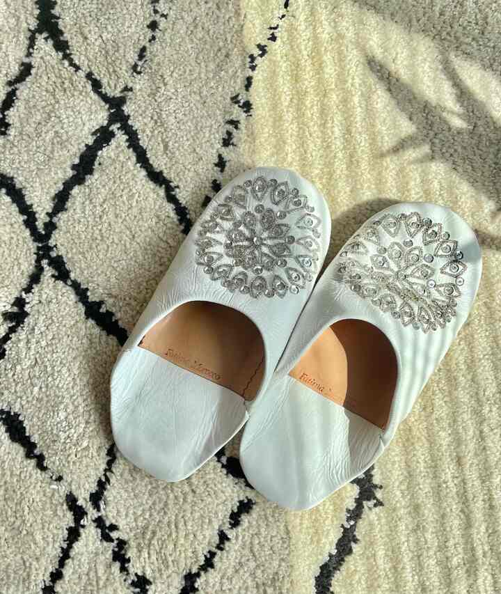 アイボリー色のラグにモロッコのバブーシュが置かれたボヘミアンスタイルのインテリア