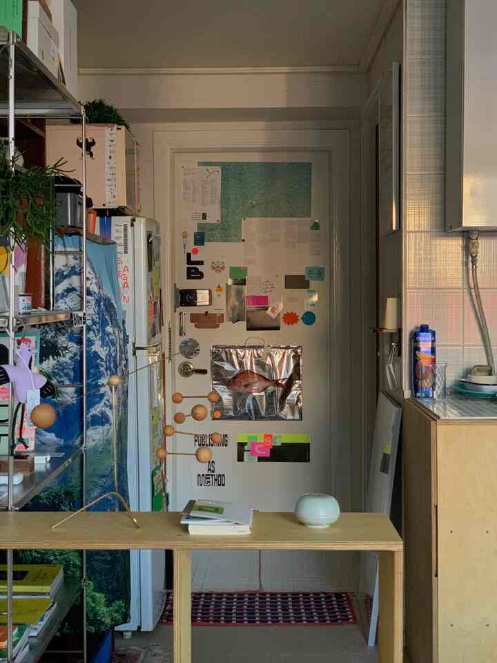 白とナチュラルカラーの調和する玄関、ポスターと収納アイデアが印象的な落ち着いた雰囲気のインテリア