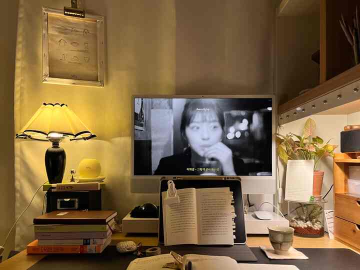 暖かい黄色の照明と木目調のデスクがあるナチュラルモダンなホームオフィス空間