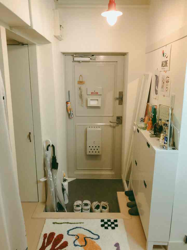 白を基調とした玄関、壁面に浅いシューズラックが置かれ、すっきりと広々した雰囲気のインテリア