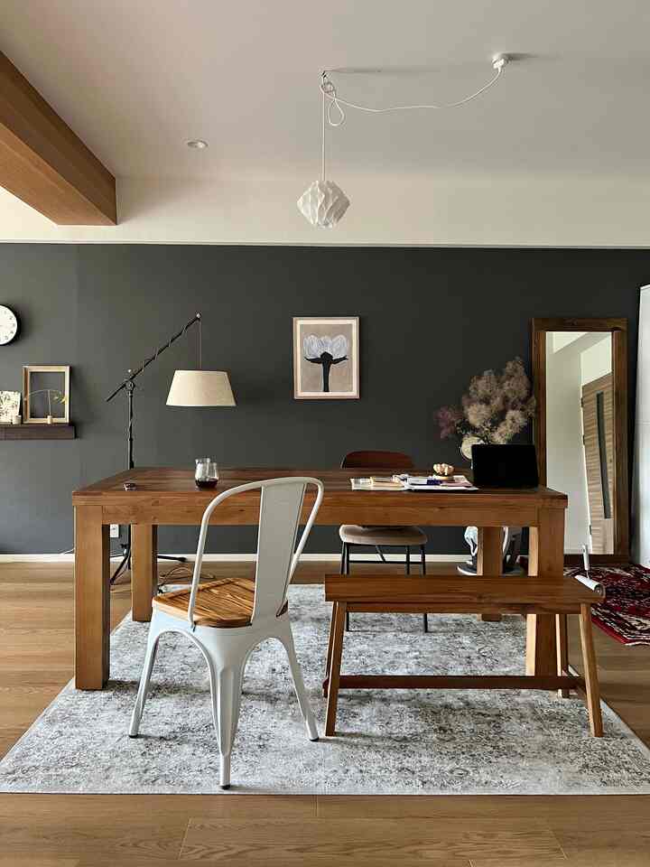 ダークグレーの壁と木製ダイニングテーブルが印象的なナチュラルでシンプルなダイニングルーム
