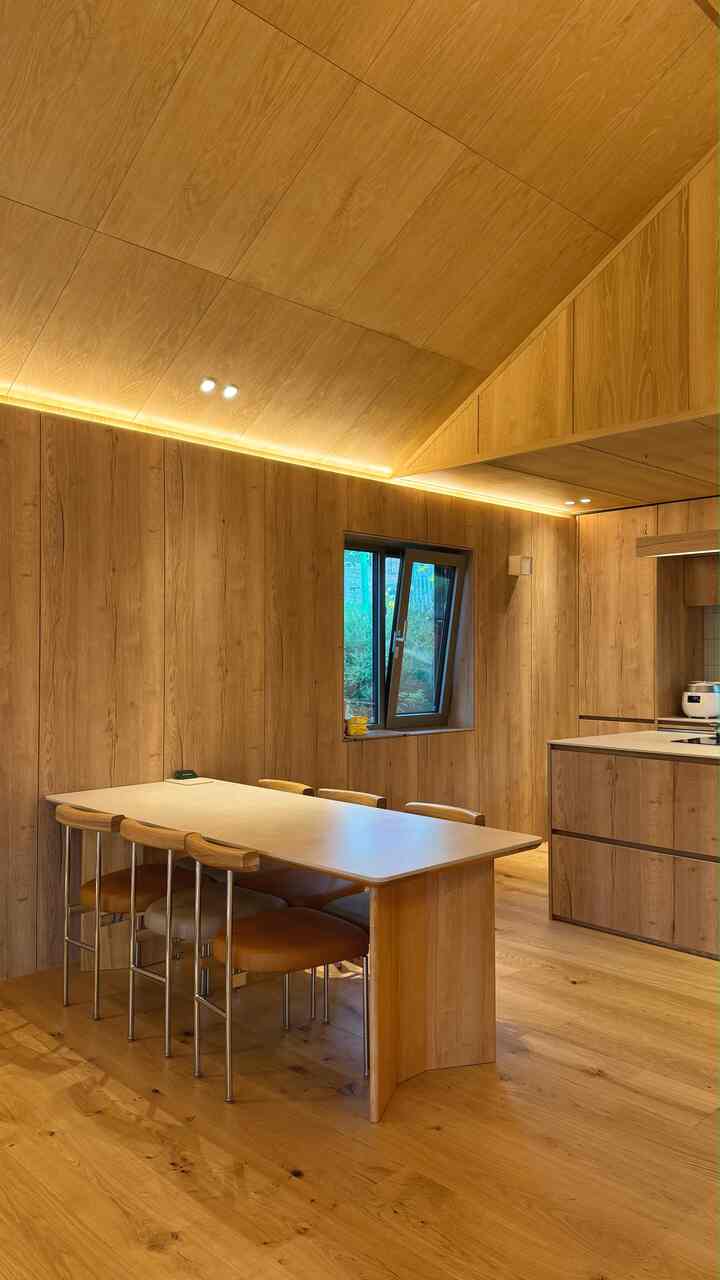 暖かい木目調で統一されたキッチン空間に6人用のダイニングテーブルと椅子が配置された雰囲気のあるインテリア