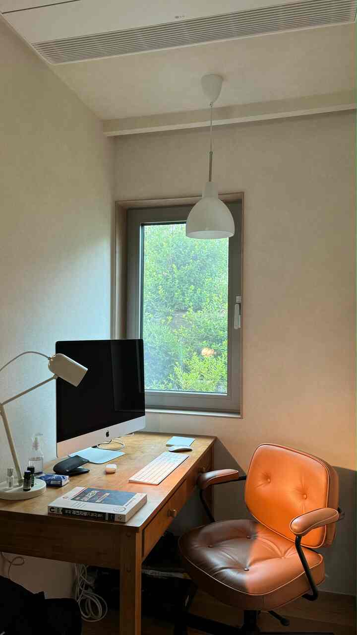 明るく温かみのある木目調のホームオフィス空間、窓の前に配置された木製デスクとオフィスチェアが整った作業環境を演出