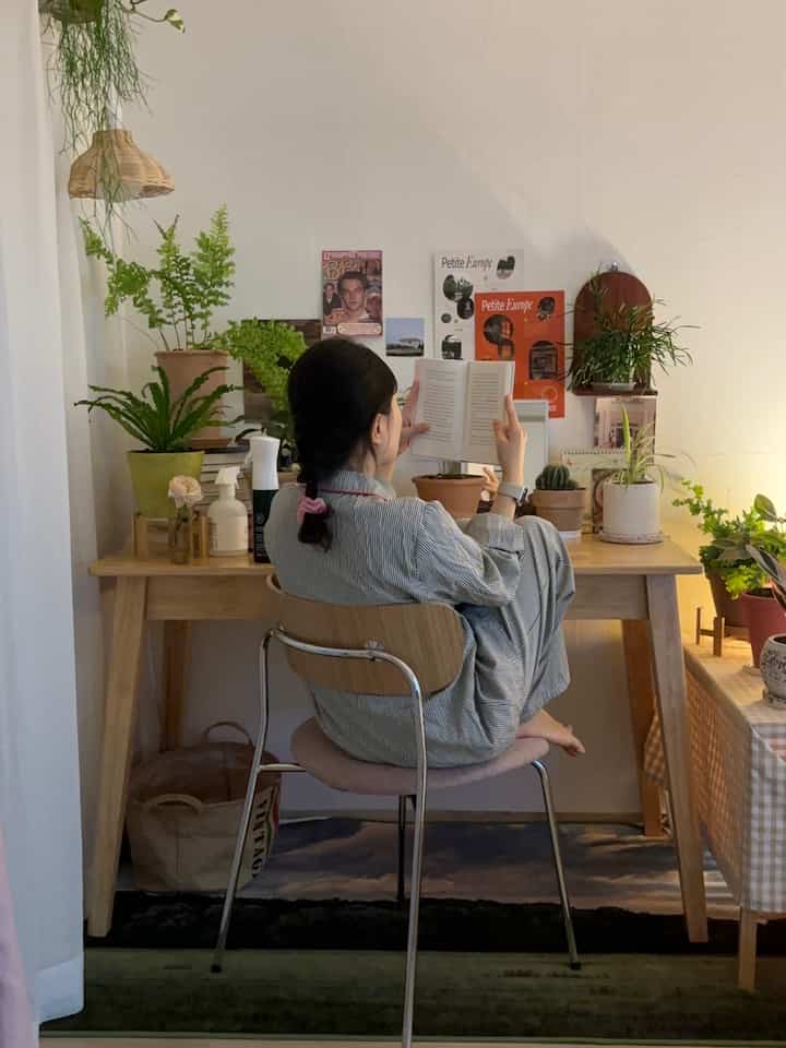 ナチュラルな色調のホームオフィス、木製のデスクと椅子、多様な植物が配置された落ち着いた読書空間