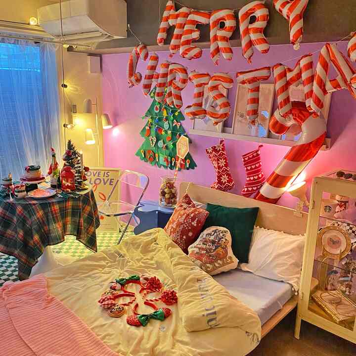 紫色の壁紙が印象的な寝室、クリスマスの装飾と居心地の良いベッドが配置された雰囲気のある空間