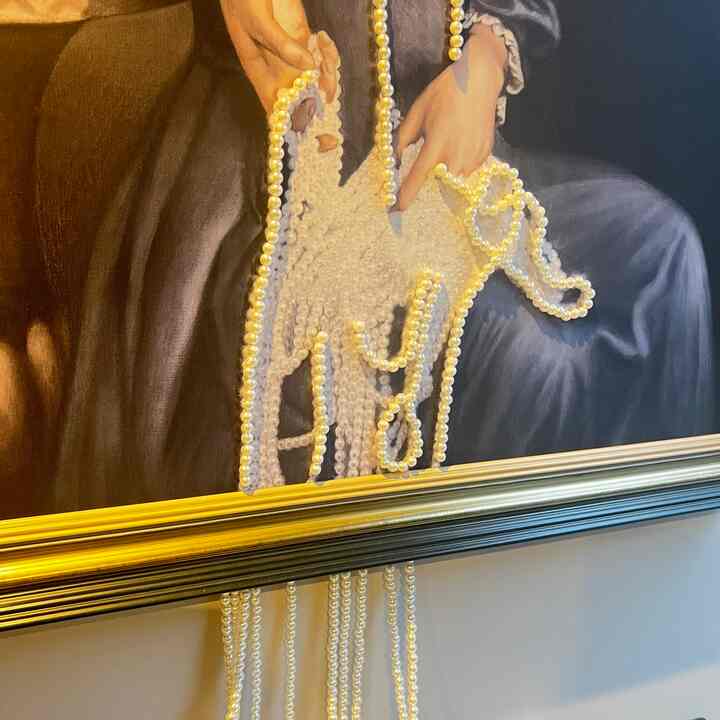 ゴールドとホワイトの額縁に囲まれた油絵にパール装飾が映える、印象的で洗練されたウォールアート