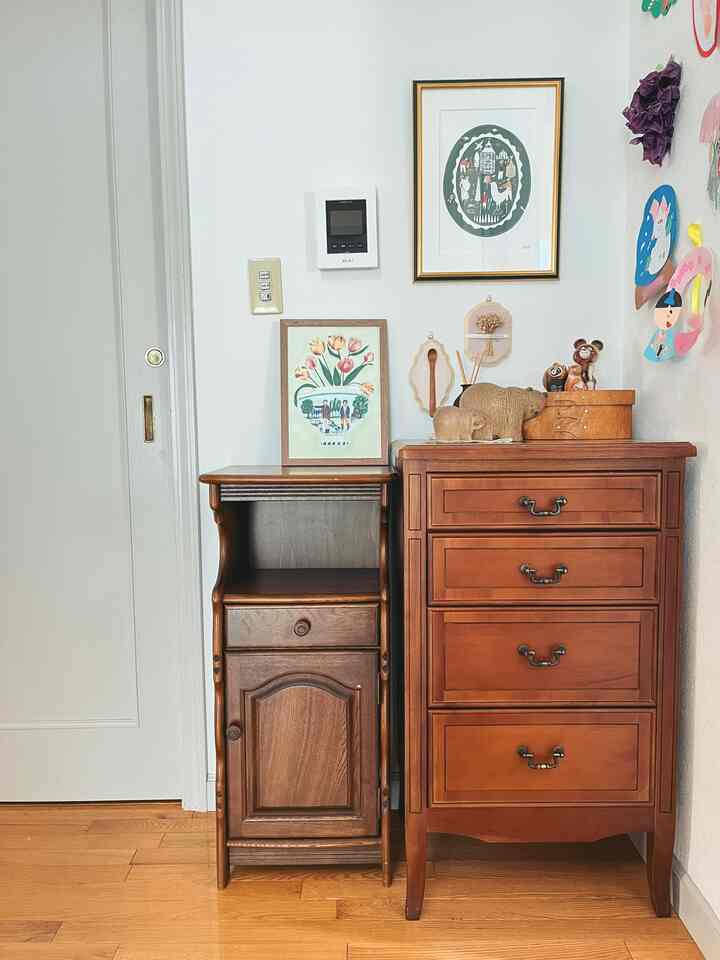 明るい白い壁とブラウンの木製電話台とチェストが配置されたナチュラルなダイニングルームのコーナー