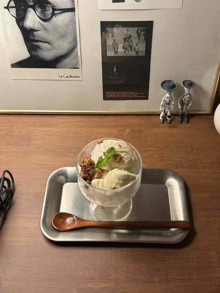 ナチュラルな木目調のテーブルにガラスのデザートボウルと木製スプーンが置かれたおうちカフェの雰囲気あるインテリア