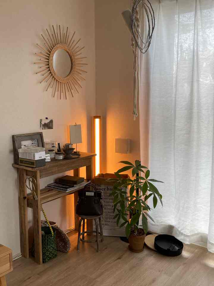 暖かいベージュと木目調のコンソールテーブルと植物が配置されたナチュラルでシンプルなリビングコーナー