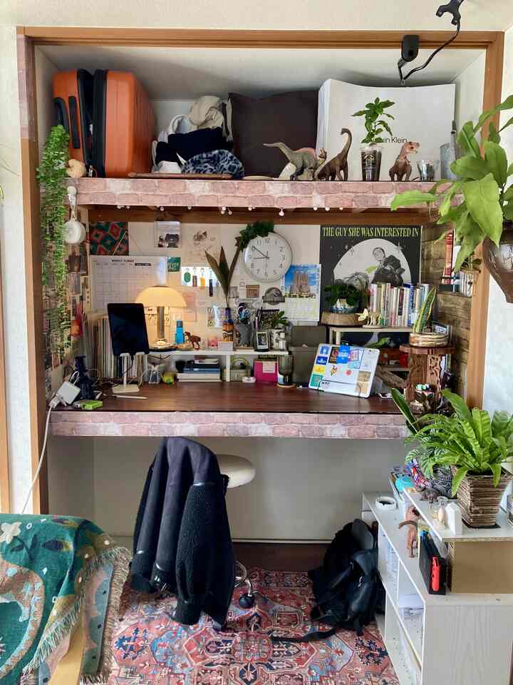 ナチュラルな色調の狭いホームオフィス、クローゼットを改装したデスクと植物が配置された集中できる空間