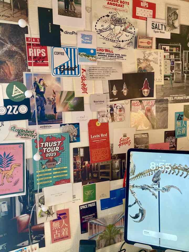 白を基調としたホームオフィス、壁に多彩なポスターやカードが並び、デスク上にiPadが置かれている雰囲気のあるインテリア
