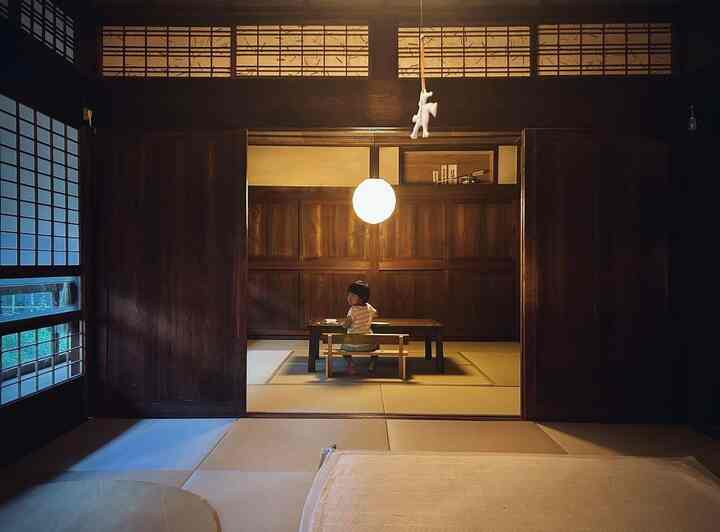 温かみのある木目調と畳敷きの6畳ダイニング、中央に子供が座る伝統的な和風インテリア