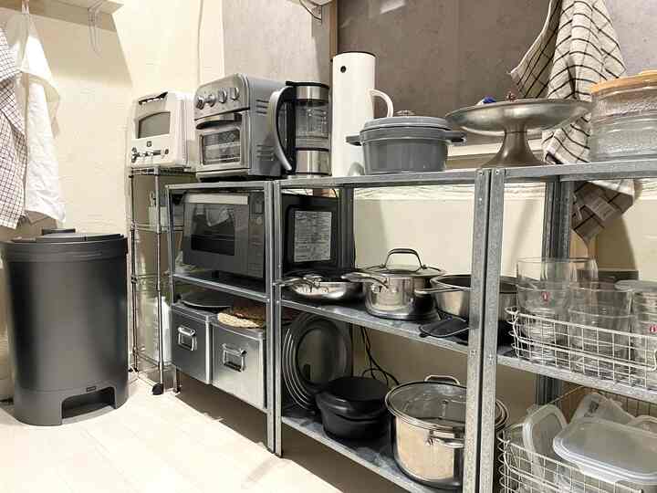 グレーのトーンのキッチン、IKEA HYLLISの棚3台とシルバーの家電や調理器具が整然と配置された実用的な空間